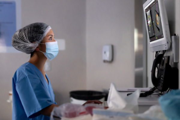 Profissional de saúde a olhar para um ecrã no laboratório