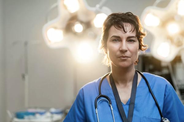 Cirurgiã a olhar para a câmara num bloco operatório