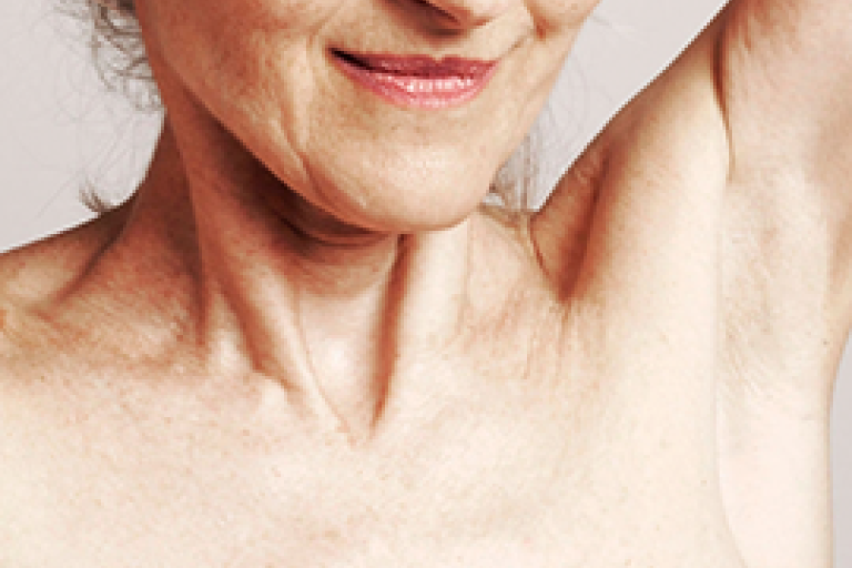 Plano aproximado do pescoço e do ombro de uma paciente a preparar-se para o exame