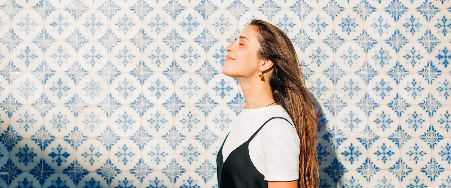 Mulher sorridente, a olhar para o lado, num dia solarengo