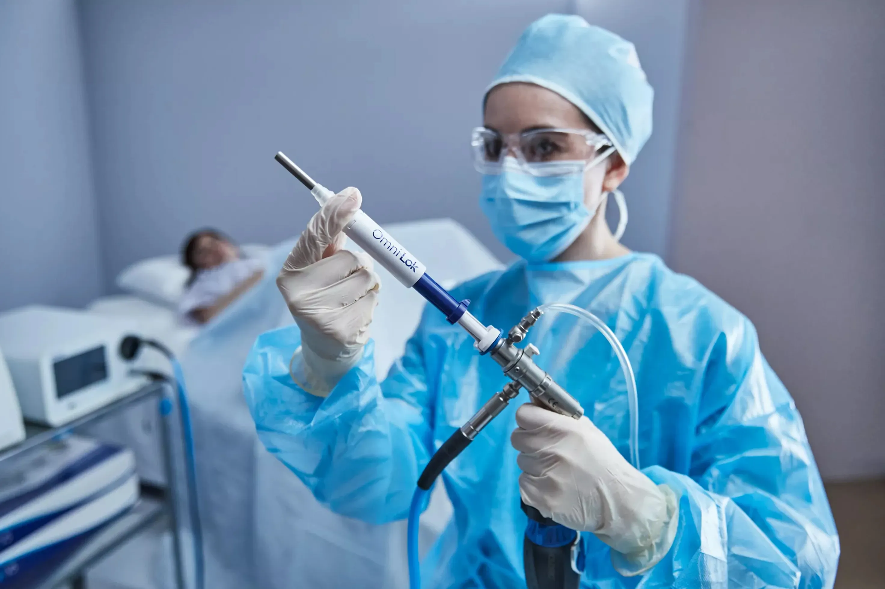 Prestador de cuidados de saúde segurando um histeroscópio Omni® e o selo em frente a uma doente.