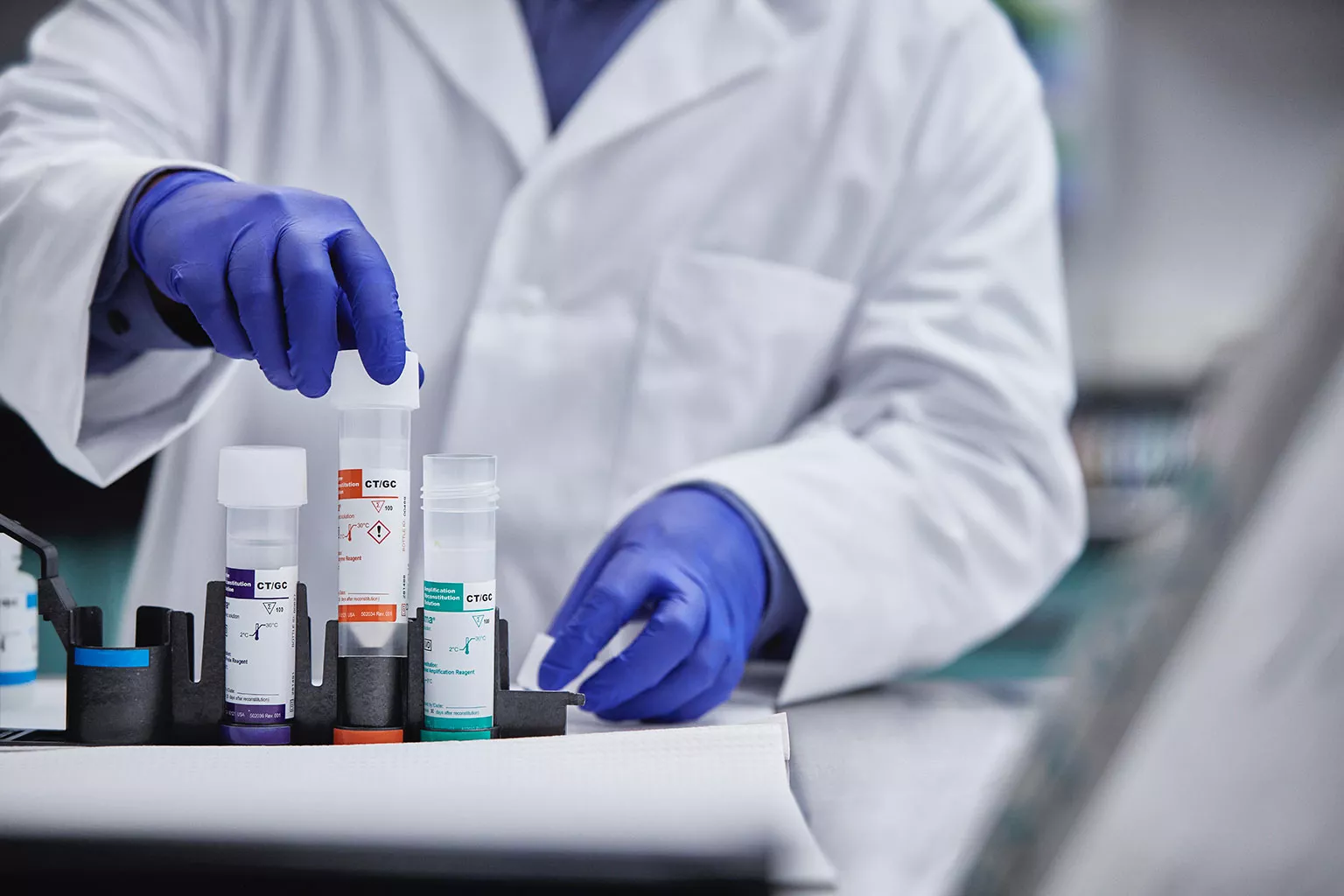 Técnico de laboratório a levantar um tubo.