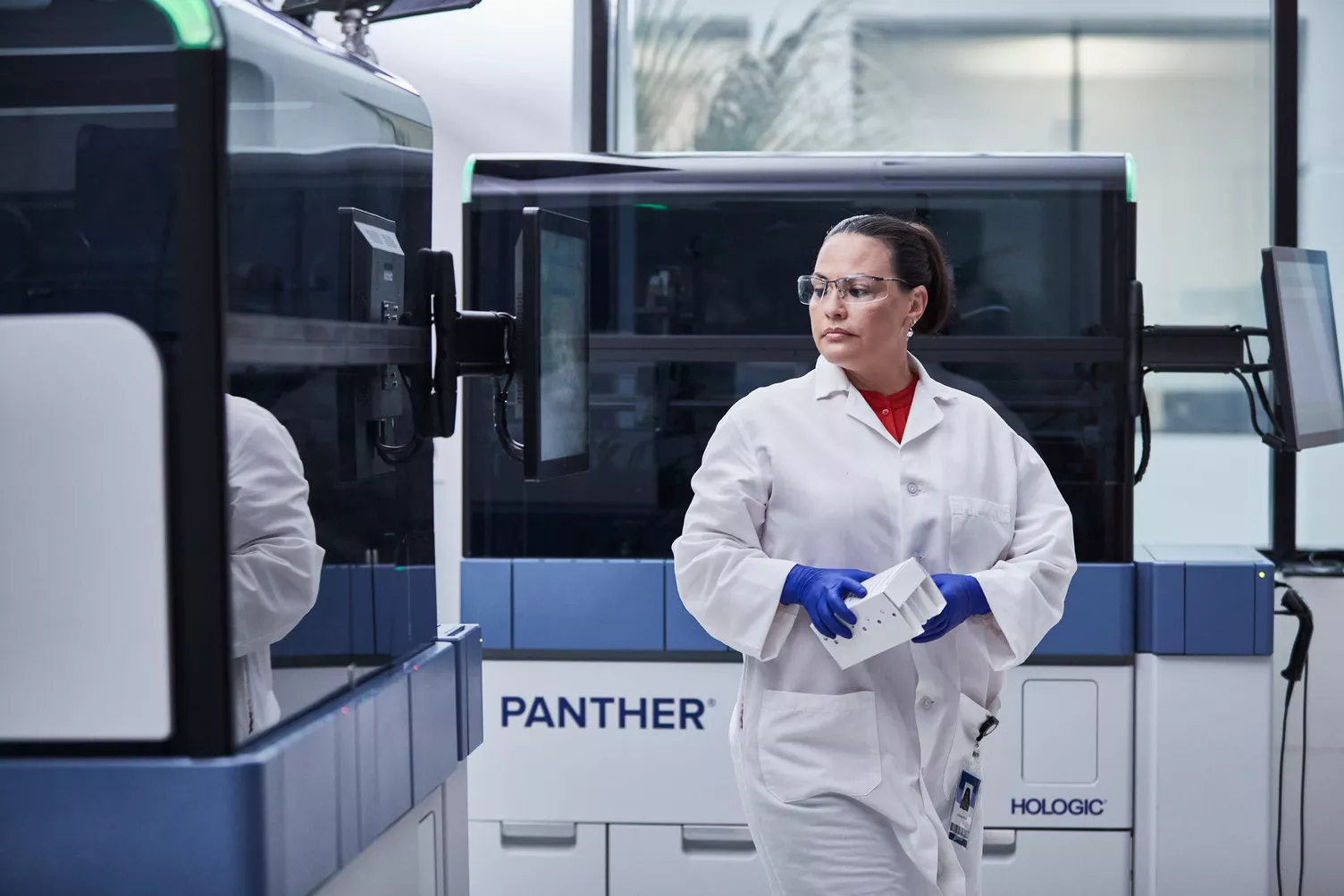Técnica a caminhar ao lado dos sistemas Panther® num laboratório