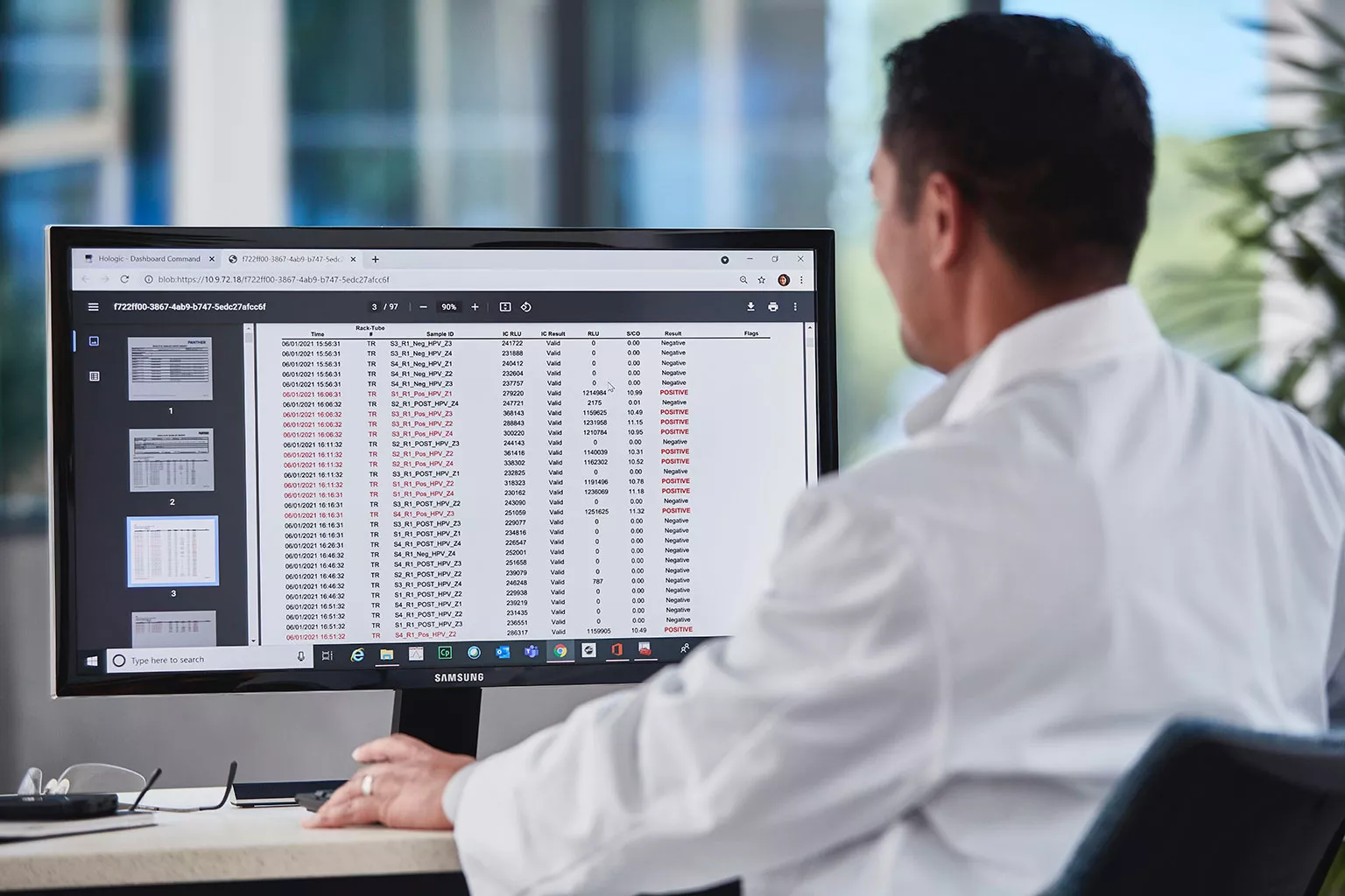 Técnico de laboratório a analisar dados no monitor.