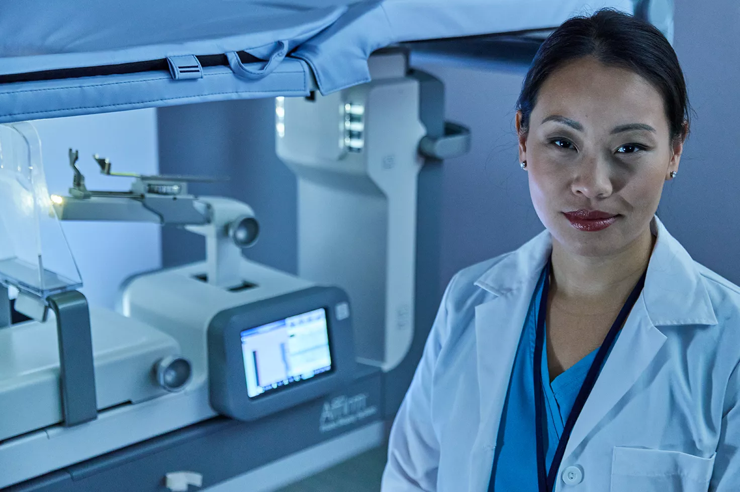 Profissional de saúde ao lado do sistema de biopsia mamária