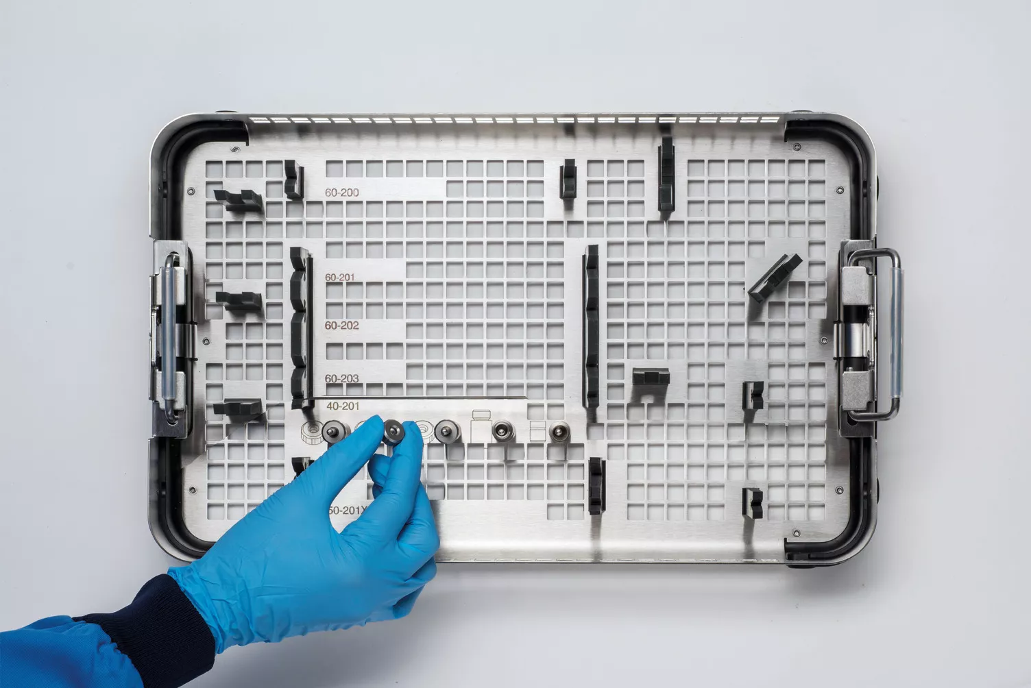 Pessoa com luvas a segurar o tabuleiro médico na mesa.