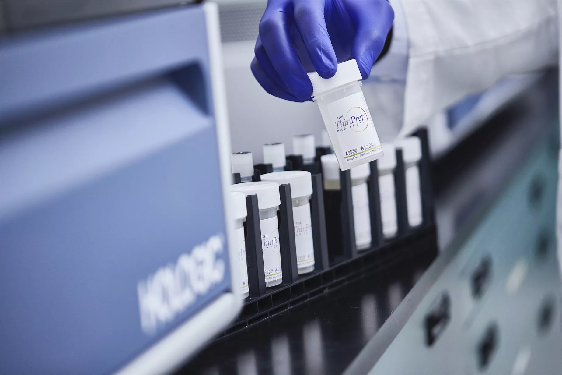 Pessoa com luva a segurar um frasco