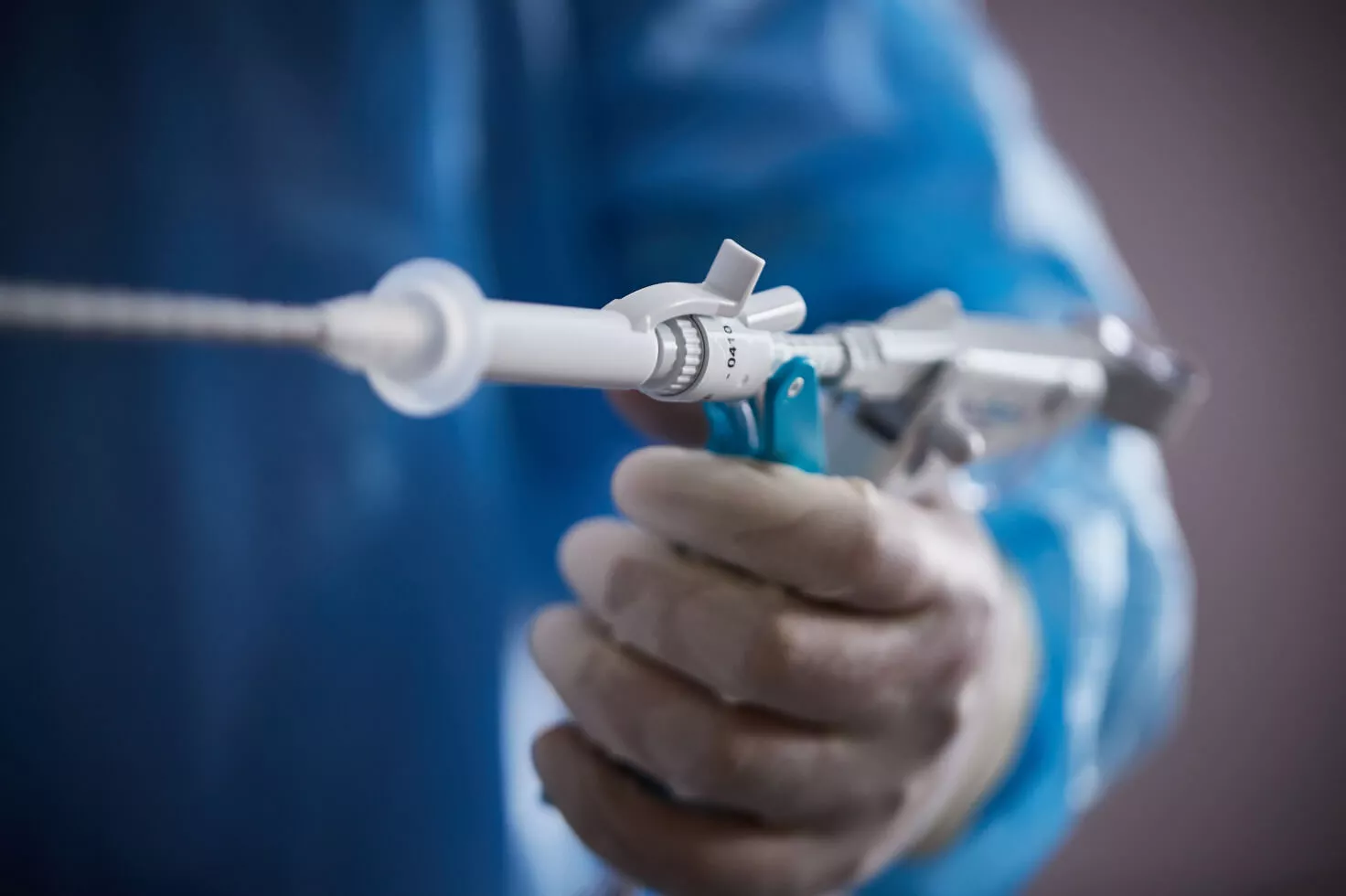 Profissional de saúde a segurar uma agulha de sistema de biopsia